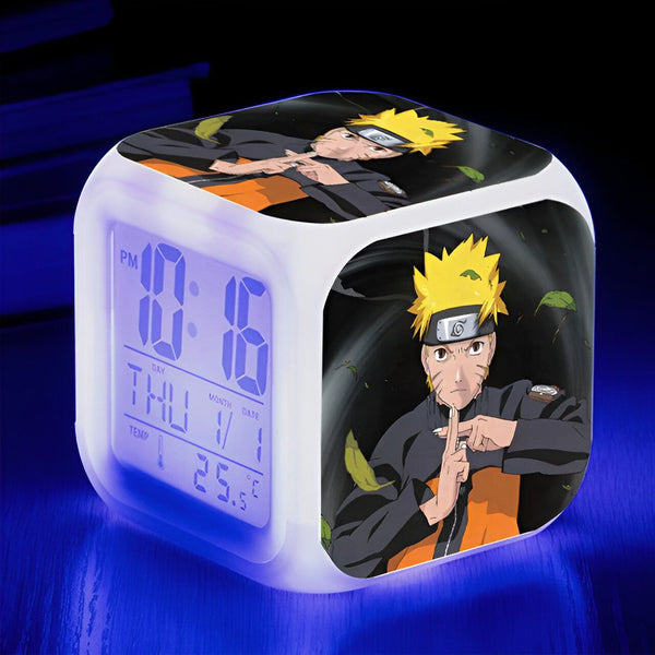 Horloge numérique blanche avec un design Naruto. L'horloge affiche l'heure, le jour, le mois, la date et la température. Naruto est représenté sur l'horloge avec un fond sombre.