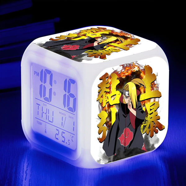 Horloge de réveil numérique avec l'image de Pain du manga Naruto. L'horloge affiche l'heure, le jour et la température. Le design de l'horloge est blanc avec un motif représentant Pain et son attaque signature.