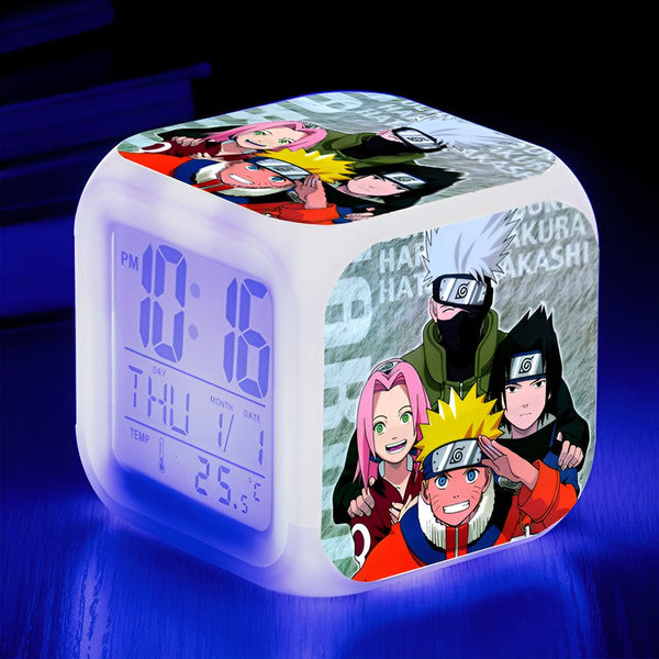 Réveil numérique avec un design Naruto. L'horloge affiche l'heure, le jour, le mois et la température. On y voit les personnages de Naruto, Sasuke, Sakura et Kakashi.