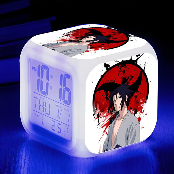 Réveil numérique avec l'image de Sasuke Uchiha du manga Naruto, sur un fond rouge avec le symbole du Sharingan. L'horloge affiche l'heure, le jour et la température.