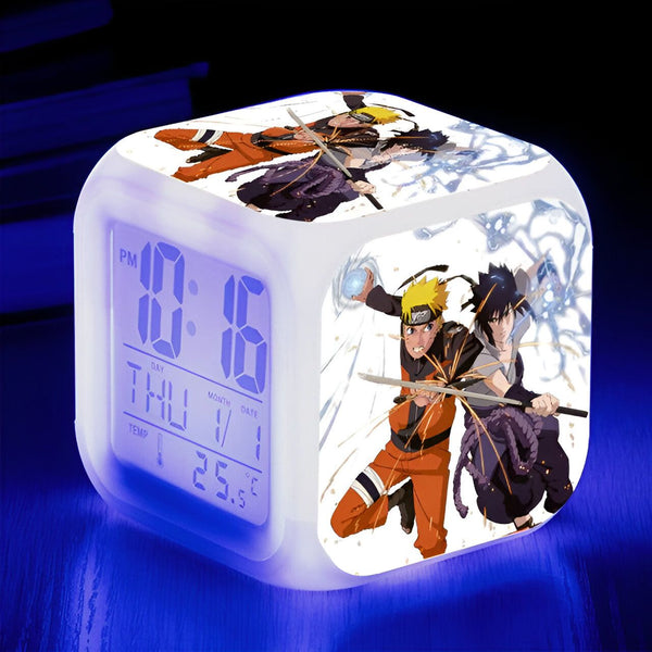 Réveil numérique avec affichage de la température et des personnages de Naruto, Sasuke et Naruto, en action.