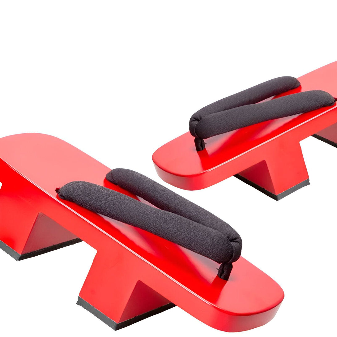 Une paire de sandales japonaises rouges traditionnelles, appelées geta, avec des lanières noires. Elles sont fabriquées en bois et sont parfaites pour les occasions spéciales ou pour un look élégant et décontracté.