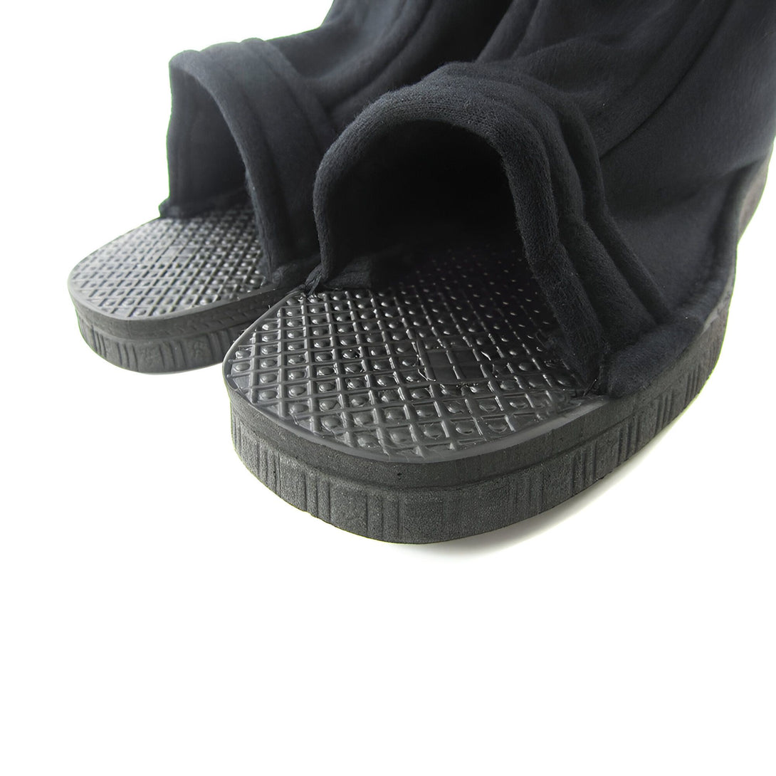 Une paire de sandales noires en tissu, style ninja, avec une semelle en caoutchouc à motif losange.  Idéales pour compléter un costume Naruto.