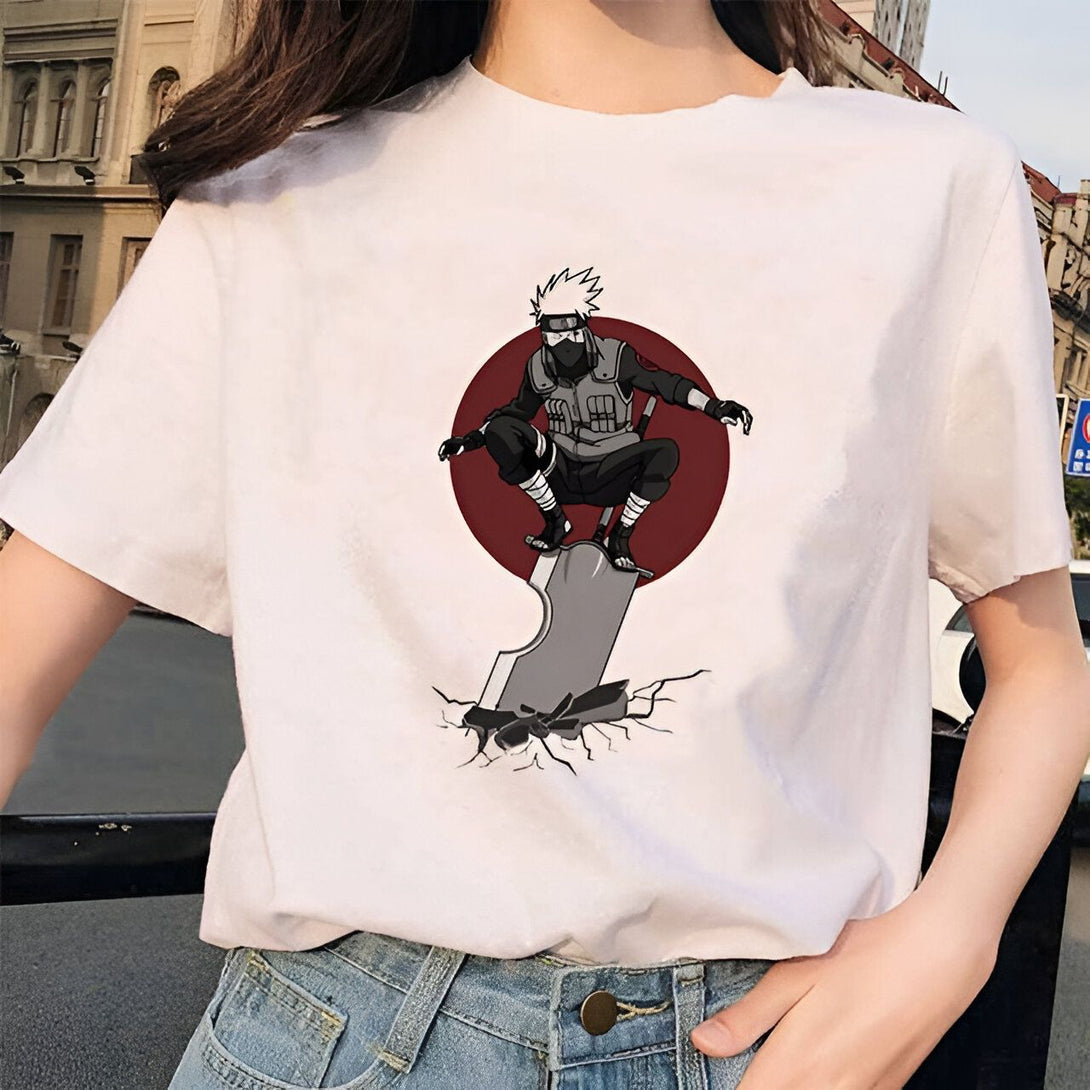 Un t-shirt blanc avec un motif d'un personnage d'anime, Kakashi Hatake, du manga Naruto, debout sur une épée brisée avec un fond rouge.