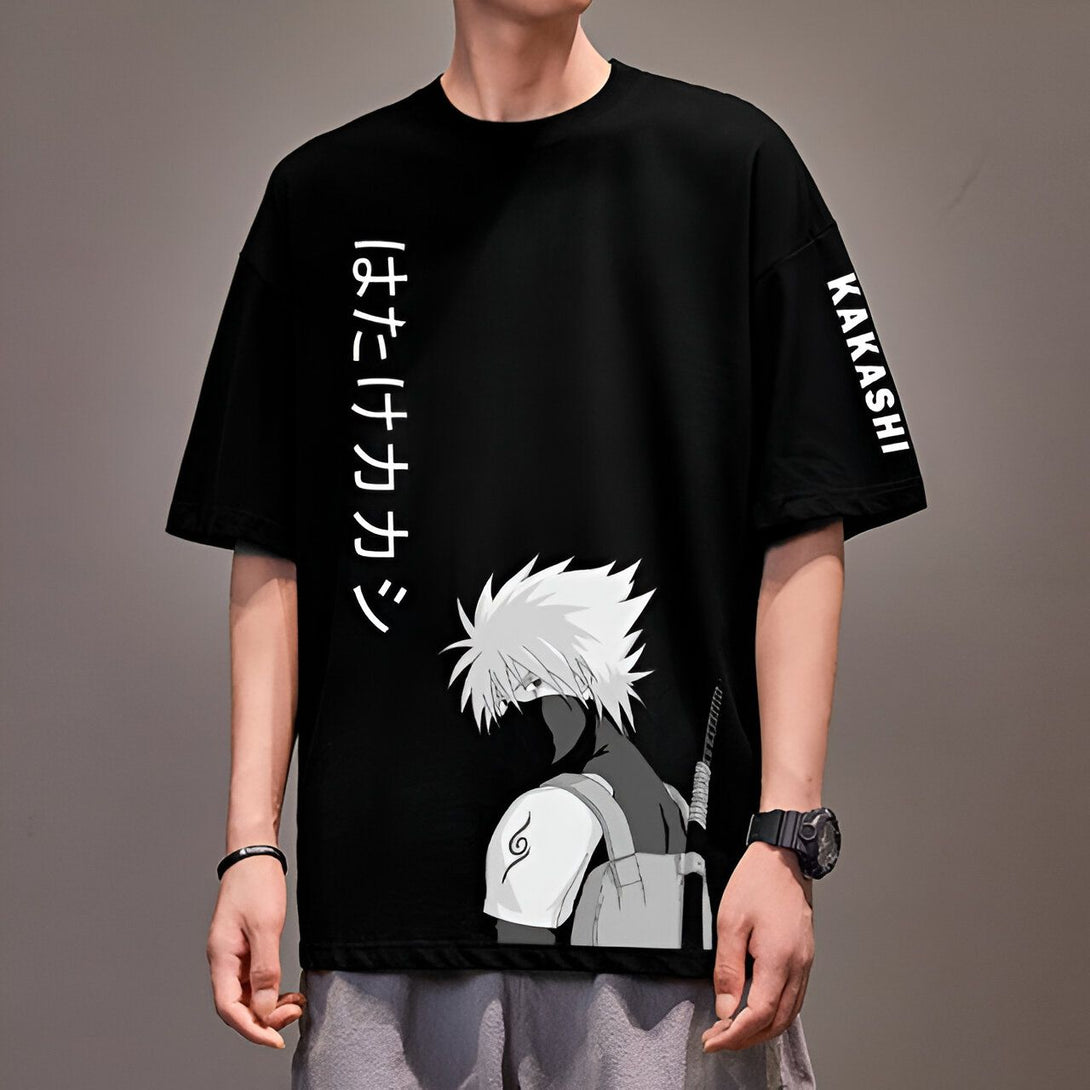 Un t-shirt noir à manches courtes avec un imprimé de Kakashi Hatake du manga Naruto. Le t-shirt comporte également le nom "Kakashi" sur la manche et des caractères japonais sur le devant.
