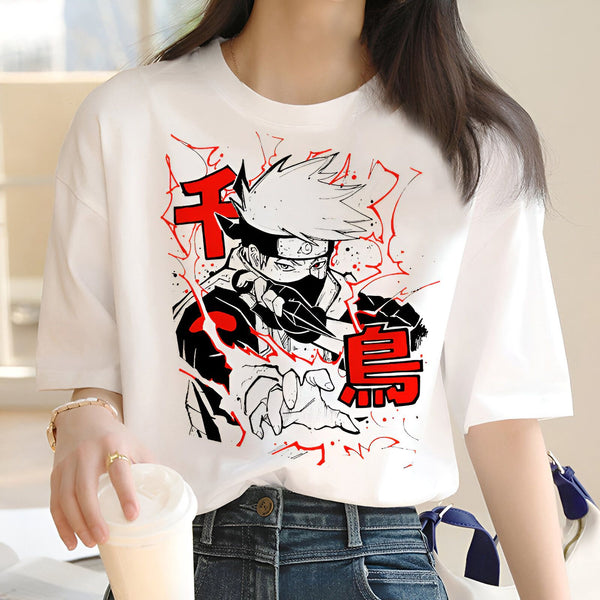 Une femme porte un t-shirt blanc avec un imprimé de Kakashi Hatake, un personnage de l'anime Naruto, en train d'utiliser son Sharingan. L'image est en noir, blanc et rouge, et représente Kakashi en action.
