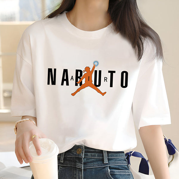 Une femme portant un t-shirt blanc avec le logo Naruto. Le logo représente le personnage principal Naruto Uzumaki en train de sauter.  Le mot "Naruto" est écrit en noir en dessous du personnage.
