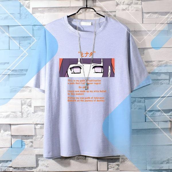 T-shirt gris avec un imprimé de Hinata Hyuga de Naruto. L'imprimé comprend une citation et un dessin de Hinata avec ses yeux violets. Le texte dit "C'est mon chemin de culture, un chemin que je ne regretterai jamais. Allez-y. J'ai maintenant établi ma croyance en ce moment. Suivez mon propre chemin de tolérance. Embarquez pour le voyage du destin."