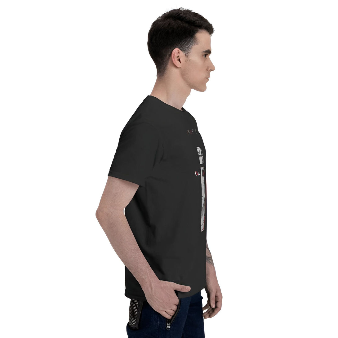 Un homme porte un t-shirt noir avec un motif imprimé de l'anime Naruto. Le t-shirt est de couleur noire et le motif est en blanc, rouge et noir. L'homme porte un jean bleu.