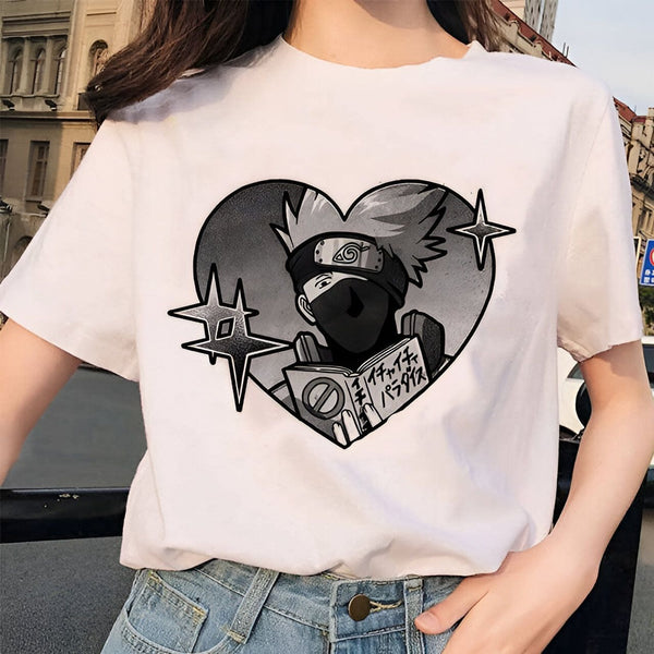 T-shirt blanc avec un imprimé en noir et blanc de Naruto Uzumaki tenant un livre dans un cœur. Il y a des étoiles autour du cœur.