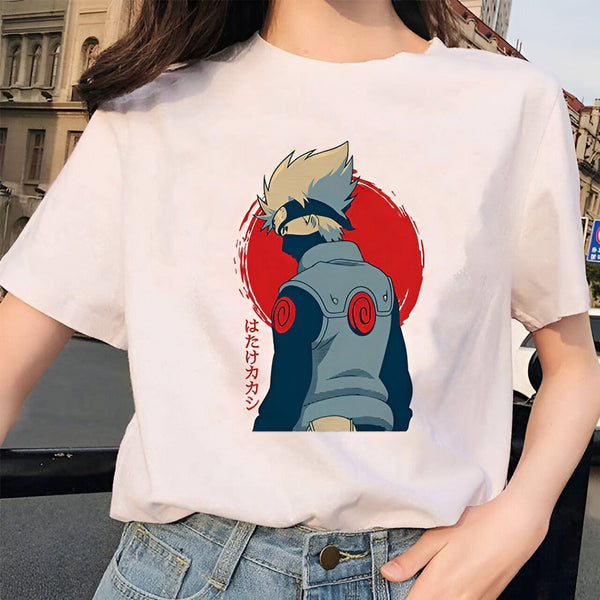 Un t-shirt blanc avec un imprimé de Kakashi Hatake de Naruto, debout devant un soleil rouge. Le t-shirt est porté par une femme avec un jean bleu.