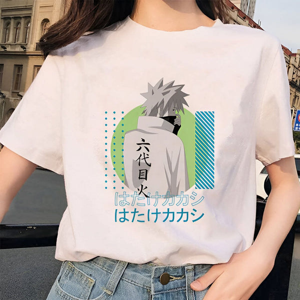 T-shirt blanc avec un imprimé de Kakashi Hatake, un personnage de l'anime Naruto, portant un bandeau avec l'inscription "Hatake". Le design est sur un fond vert avec des motifs géométriques bleus et blancs.