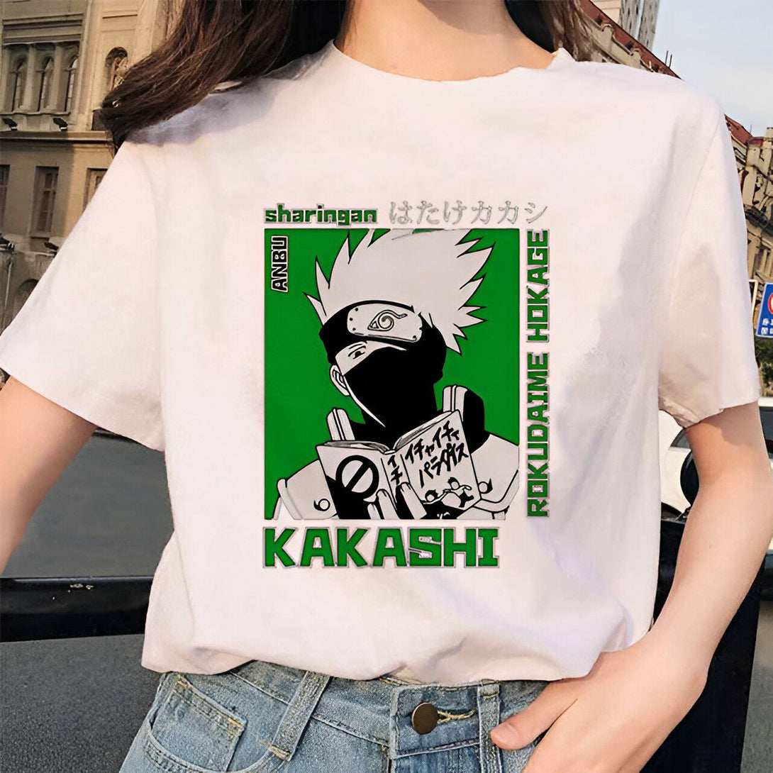 Un t-shirt blanc avec une image de Kakashi Hatake, un personnage de l'anime Naruto, portant un masque noir et lisant un livre. Le texte "Sharingan" et "Kakashi" sont écrits en noir sur un fond vert. Le t-shirt est un article officiel de Naruto.