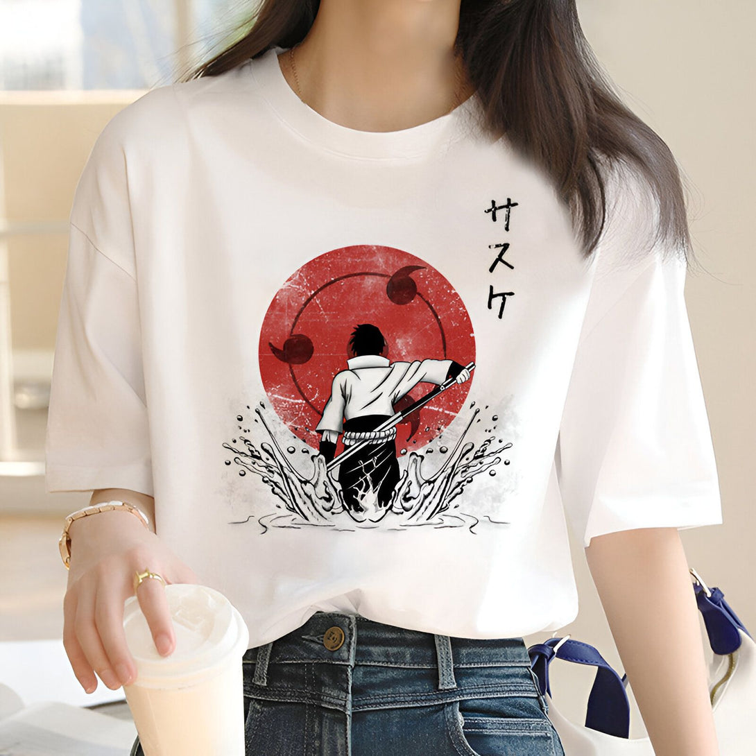 Un t-shirt blanc avec un imprimé de Sasuke de Naruto, debout devant le symbole du Sharingan, avec de l'eau qui éclabousse autour de lui.