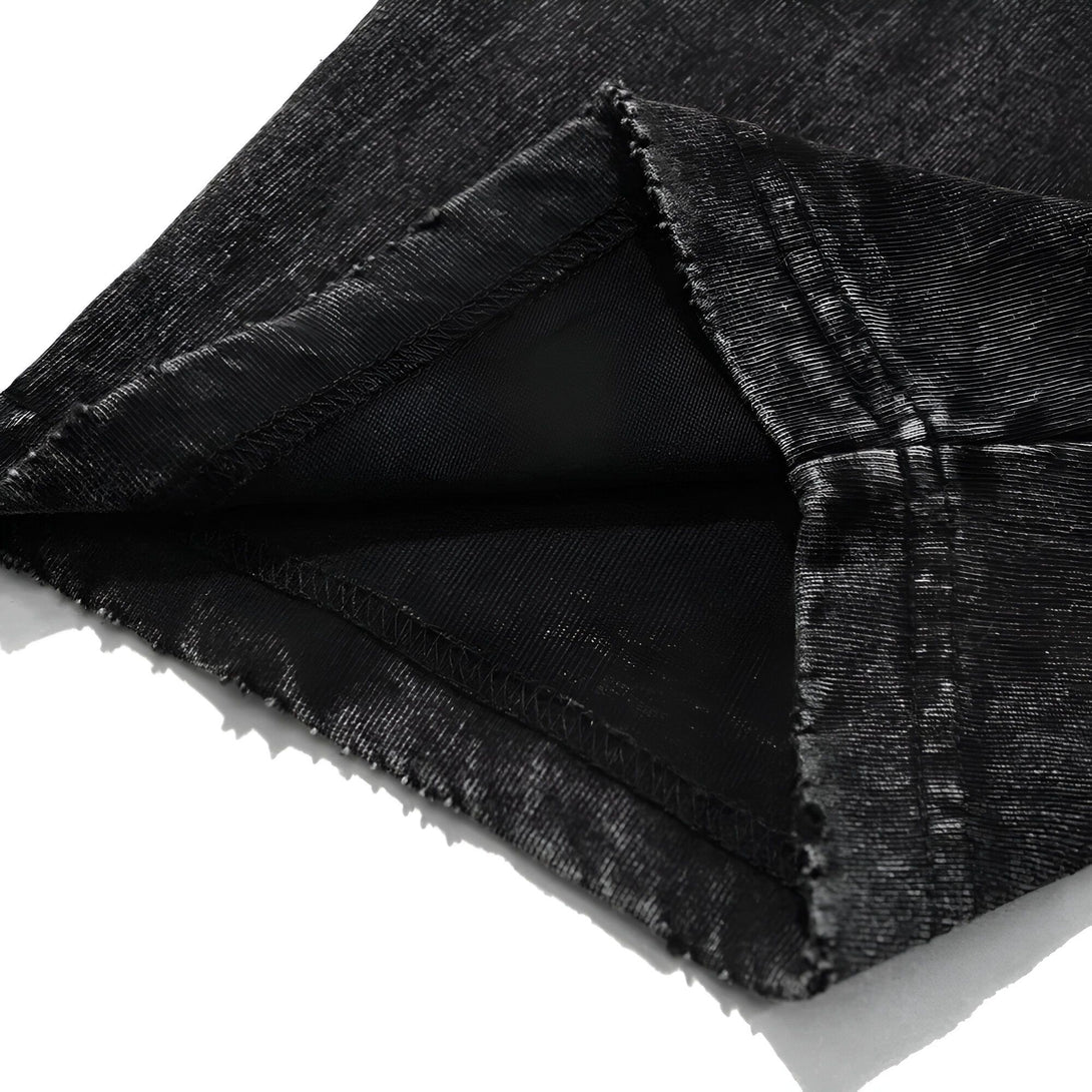 Détails du bas d'un t-shirt noir en coton avec un effet délavé, montrant la couture et la qualité du tissu.