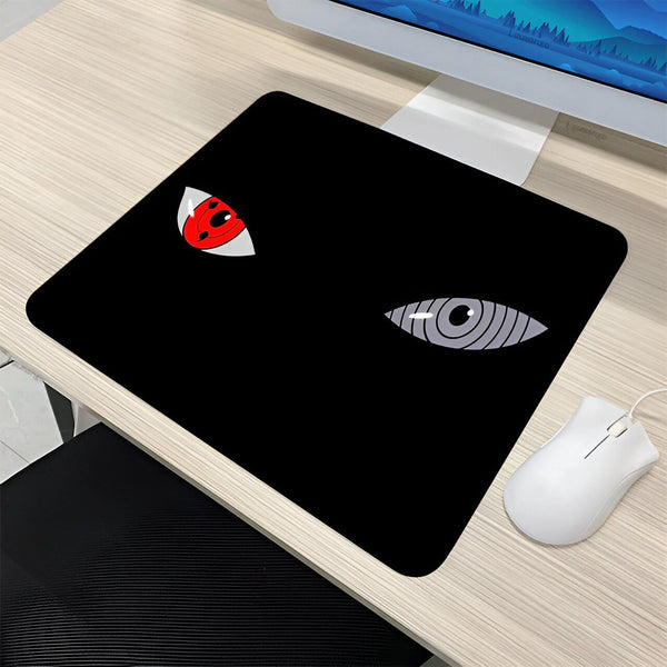 Un tapis de souris noir avec deux yeux de manga, l'un rouge avec un Sharingan et l'autre gris avec un Byakugan.